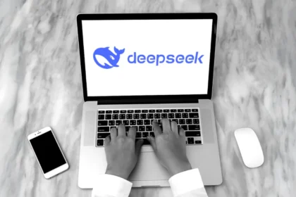 Deepseek aplikacija na laptopu pored mobitela i miša
