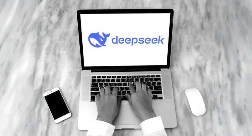 Deepseek aplikacija na laptopu pored mobitela i miša
